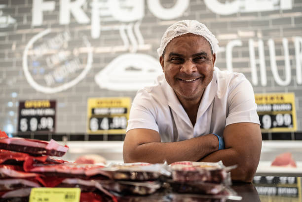 porträt eines metzgers hinter der theke - supermarket meat store manager stock-fotos und bilder