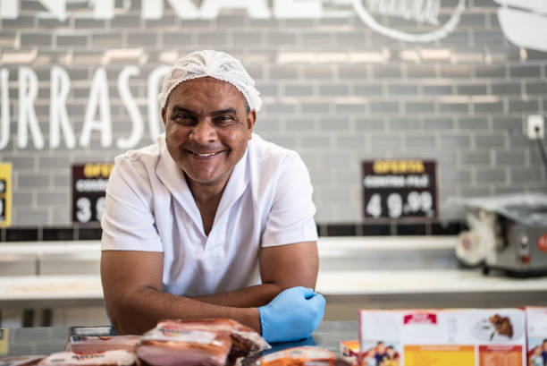 portrait of a butcher behind the counter - supermarket meat store manager imagens e fotografias de stock