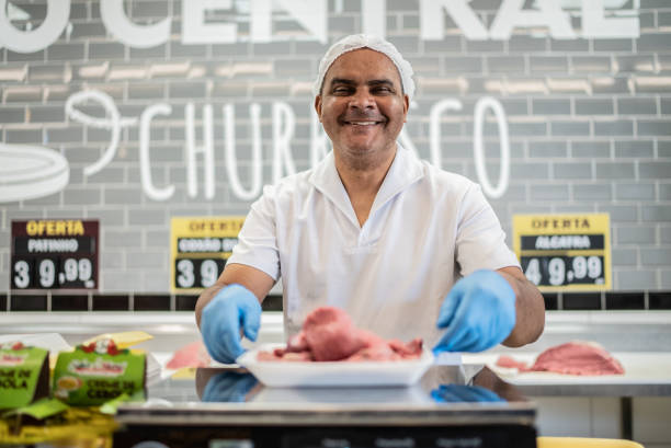 porträt eines metzgers hinter der theke - supermarket meat store manager stock-fotos und bilder