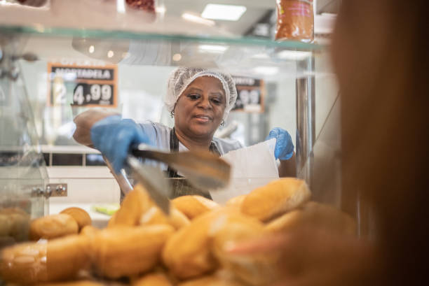 istock Employee getting some bread to customer in a bakery 1423348897
