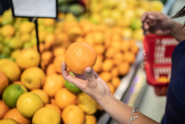 A wide-angle shot of a brightly lit refrigerated display case in a grocery store, showcasing a colorful variety of fresh fruits and vegetables neatly arranged on multiple shelves, ready for purchase.