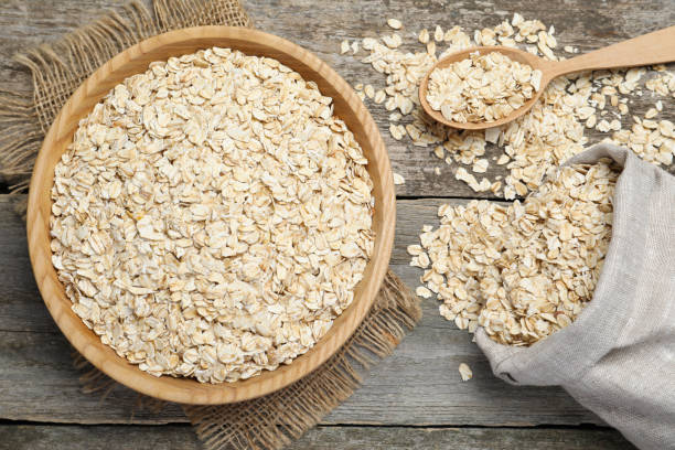 istock Oatmeal, bowl, spoon and bag on wooden table, flat lay 1423354825