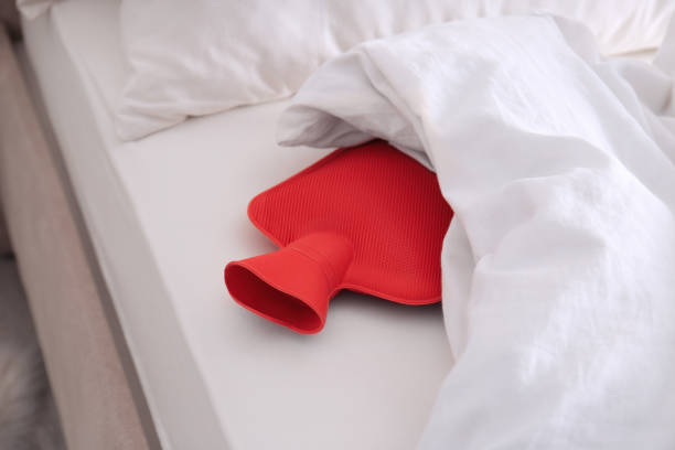 istock Red hot water bottle in bed indoors 1423356277