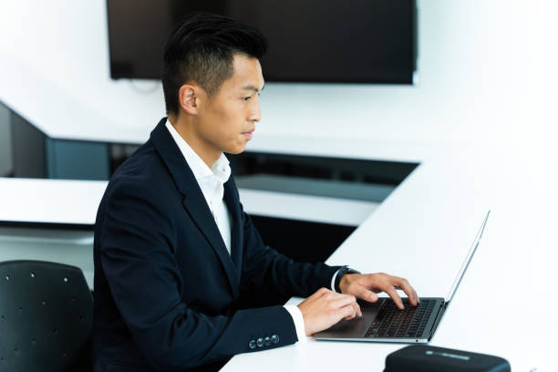 istock Asian young businessman working on his laptop while sitting in modern office space 1423356748