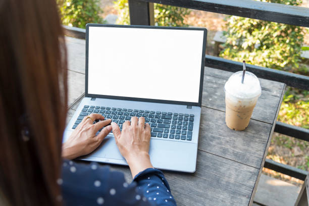 fermez les mains des femmes à l’aide d’un ordinateur portable assis dans le jardin du café. vue de dessus femme freelance de type travail clavier d’ordinateur ecran vide. ecran vide ordinateur portable blogger femme mains tapant clavier d’ordinat - regarder par dessus son épaule photos et images de collection