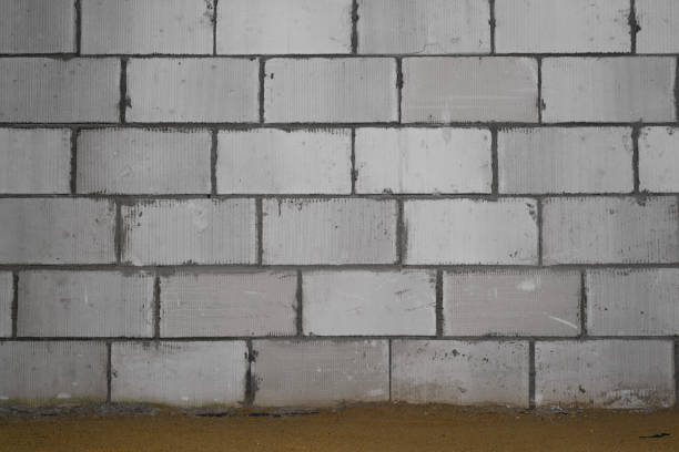 Close-up of wall of foam blocks and cement inside building and floor of sand. Construction site concept stock photo