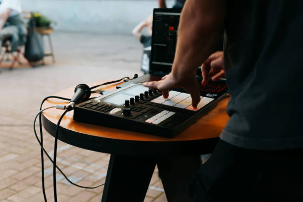 vista laterale dell'irriconoscibile beatmaker musicista di strada che suona ritmi hip hop sul controller midi della drum machine al festival all'aperto, messa a fuoco selettiva - instrumental hip hop immagine foto e immagini stock