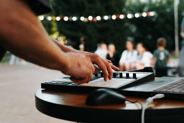 musicista beatmaker che suona su un controller elettronico di drum machine al festival di musica di strada, primo piano. messa a fuoco selettiva sul controller midi e sulla mano - instrumental hip hop immagine foto e immagini stock