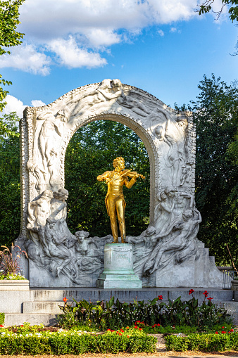 Vienna, Austria - August 12, 2022: gilded bronze monument of Johann Strauss II, unveiled to the public on 26 June 1921 and framed by a marble relief made by Edmund Hellmer