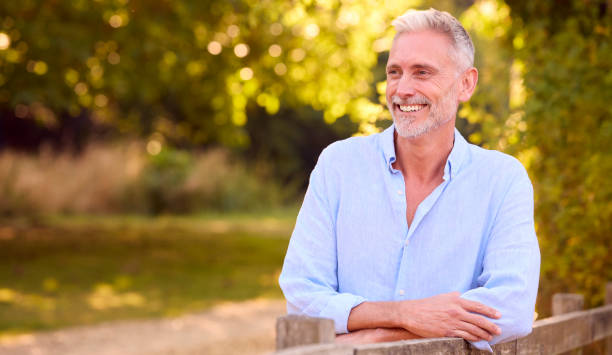 istock Casually Dressed Mature Man Leaning On Fence On Walk In Countryside 1423366126