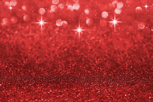 Red defocused shiny with stars and glitter, shimmer and sparkle background. Christmas, New Year. Copy space