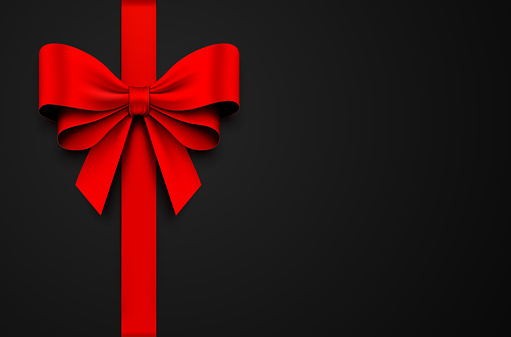 Vector illustration. Red gift bow with ribbon on a black background.
