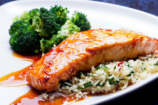 Asian glazed salmon on a bed of rice with broccoli