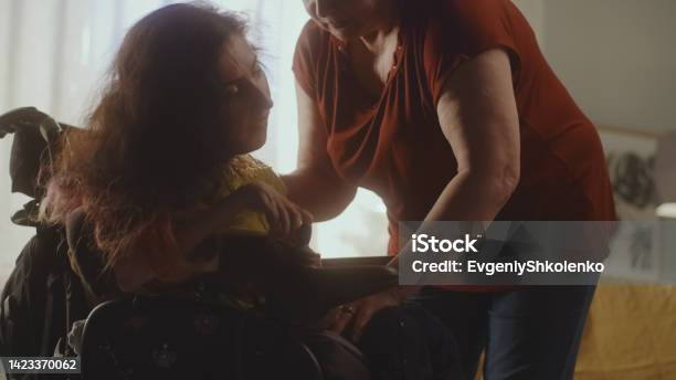 Caregiver Helping Woman To Sit In A Wheelchair Stock Photo - Download Image Now - Legal Guardian, Senior Adult, Senior Animal