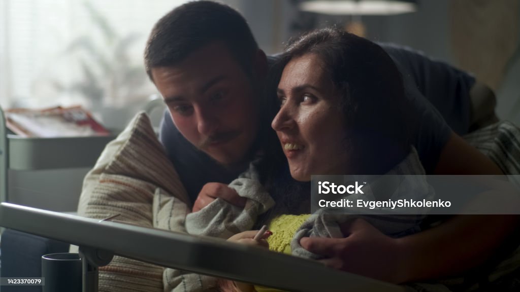 Woman drawing on tablet at home with husband Woman with a disability sitting on a couch at the table, using digital tablet computer and pencil while her husband entering the room and covering her with a blanket 20-24 Years Stock Photo