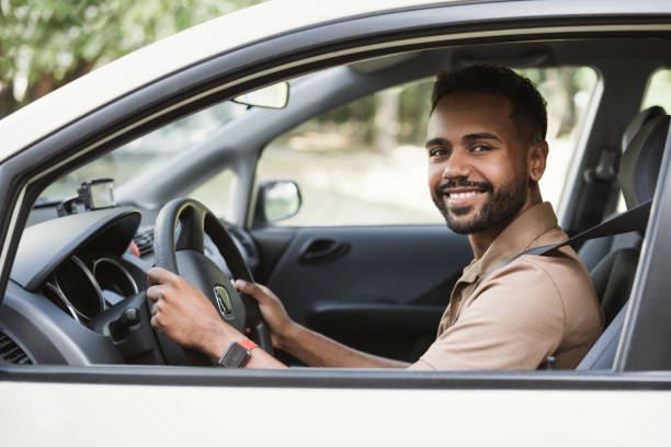 istock Smiling young man driving a car 1423370791