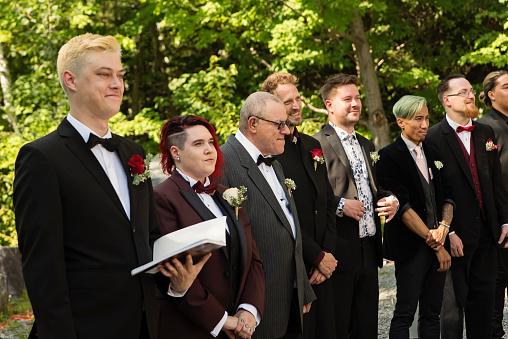 Red hair bride and grooms at LGBTQ+ wedding ceremony. This is part of a series about a lesbian couple getting married. Horizontal outdoors waist up shot with copy space.