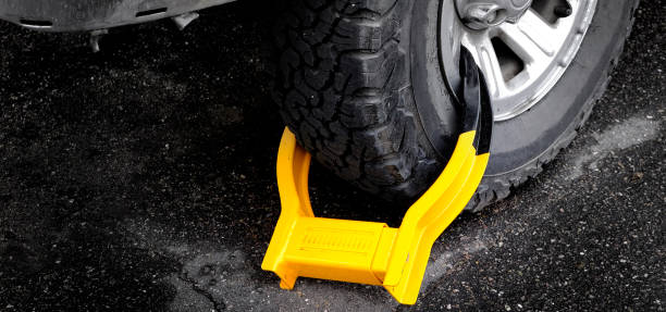Wheel Boot or Tire Lock for Illegal Parking Violation Immobilize Vehicle Car Wheet boot or tire lock on a vehicle or car for illegal parking violation car boot stock pictures, royalty-free photos & images