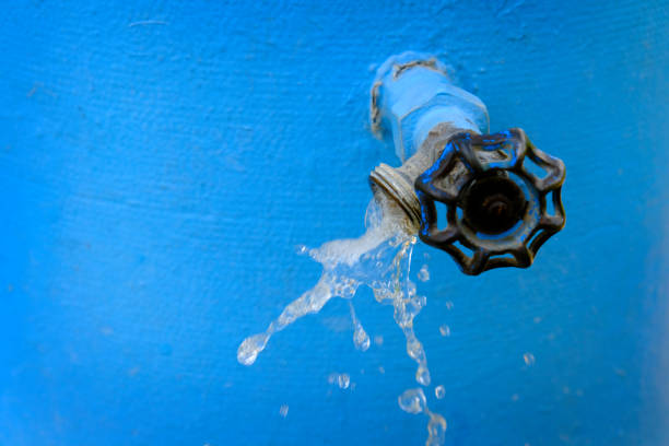 Water faucet spraying cool water flowing with drops blue