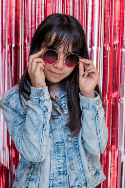 vertical portrait of a teenage girl with a jacket and glasses, with a fashion style - pre teen boy flash imagens e fotografias de stock