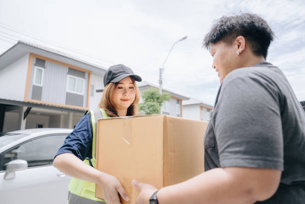 istock A young courier women brought a parcel to happy customer asian man. 1423373606