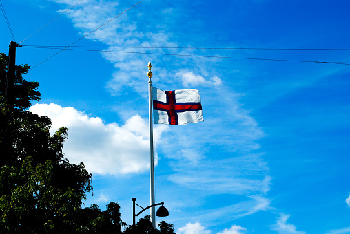 A flag featuring the St George's Cross, flying in the wind on a summer's day.