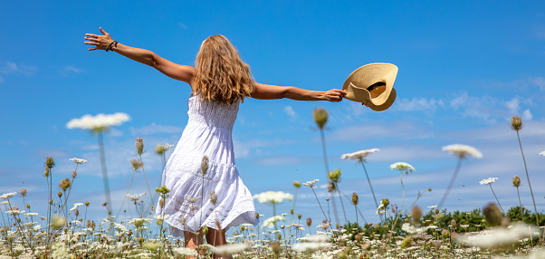 Woman dancing in a field with flower ( freedom, active, healthy, happiness concept)
