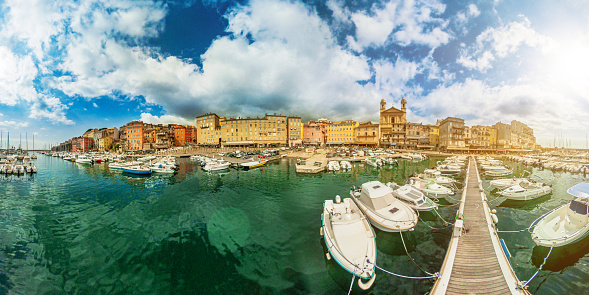 360 aerial view on the pier jetty of Bastia city with boats and yachts docked. Drone view of cityscape downtown with the city port in Mediterranean sea in Corsica island of France. 360 degrees panorama