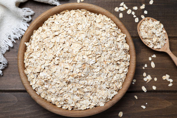 istock Bowl and spoon with oatmeal on wooden table, flat lay 1423378053