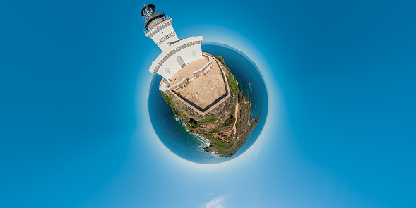 tiny planet view of seascape and the lighthouse with the Genoese tower in Mediterranean sea and tourists. Aerial 360 panoramic view of Sanguinaires islands of Corsica in France.