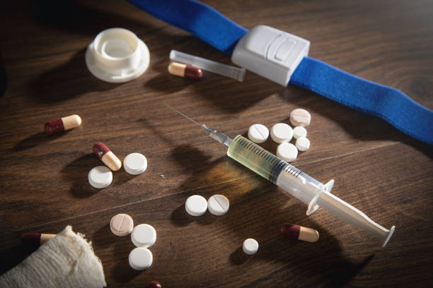 istock Pills and syringe on the wooden table. 1423379160