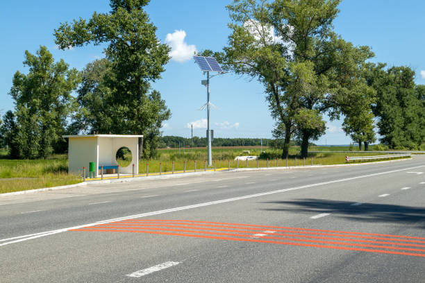 poste de luz com sistema de painéis solares na estrada com céu azul e árvores. iluminação pública autônoma usando painéis solares. lâmpada de rua, em baterias do sol. sistemas alternativos de energia renovável nas ruas. - choice street road beginnings - fotografias e filmes do acervo