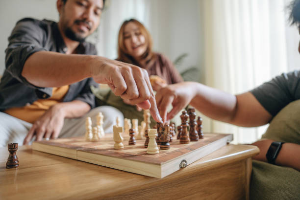 istock Friends playing a chess game and thinking in a living room. 1423381294