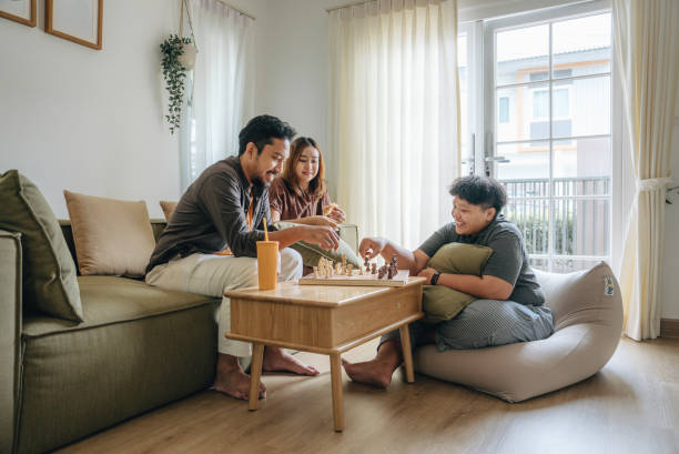 istock Friends playing a chess game and thinking in a living room. 1423381309