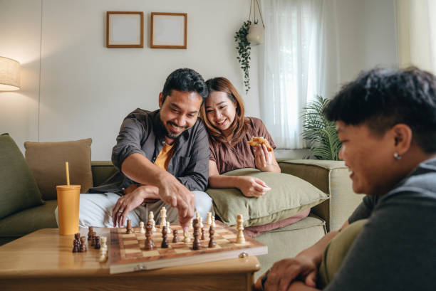 istock Friends playing a chess game and thinking in a living room. 1423381319