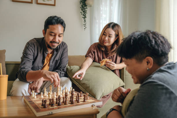 istock Friends playing a chess game and thinking in a living room. 1423381344