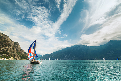 Italian colorful sail boat on Lake Garda during the international sailing regatta Centomiglia. The international sailing regatta Centomiglia is one of the most important water sports events; for more than half a century; the best European sailors have come together to compete against each other on Italy's largest lake.