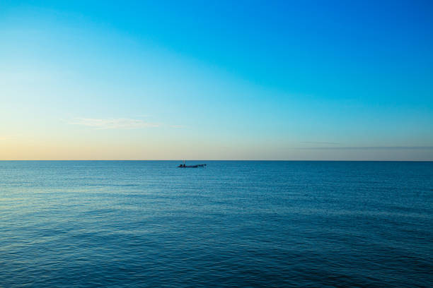 mar y pequeños barcos de pesca,un pequeño barco de pesca en medio del mar al atardecer - retro fish day sunset sunlight fotografías e imágenes de stock