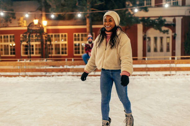 istock Woman ice skating boyfriend watching. 1423384647
