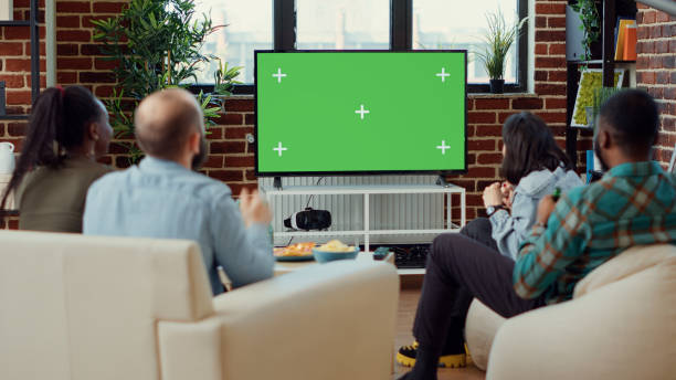 Soccer fans watching football match using greenscreen on television Soccer fans watching football match using greenscreen on television, enjoying sport game tournament on isolated copyspace. Looking at blank mockup template and background on tv. excited football fan cheering for his team on tv stock pictures, royalty-free photos & images