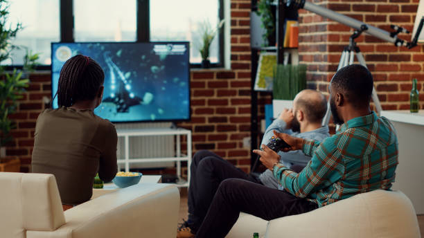 istock Happy people playing video games and winning competition 1423385404