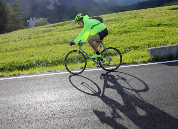 istock young cyclist with racing bicycle and phosphorescent waterproof jacket on the road 1423386425