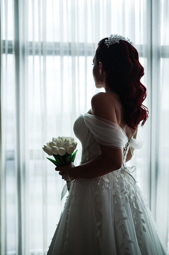 The bride and Father are standing next to each other and a Father holds her Arm. Slim beautiful young bride holding her father's hand before her wedding. Bride and Father Arm in Arm.