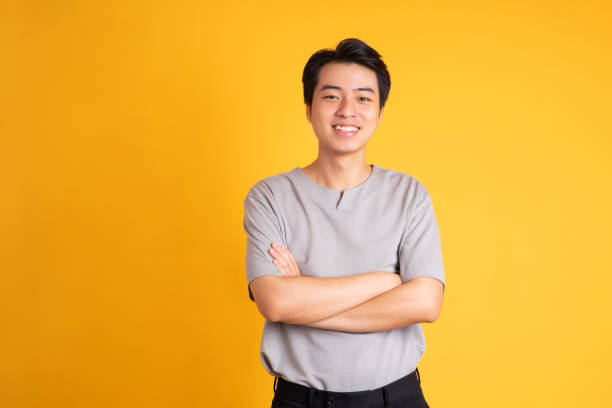 istock Asian young man posing on a yellow background 1423386765