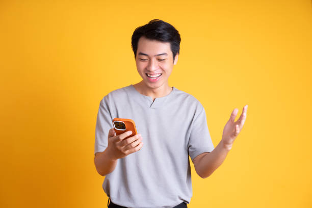 istock Asian young man posing on a yellow background 1423387298