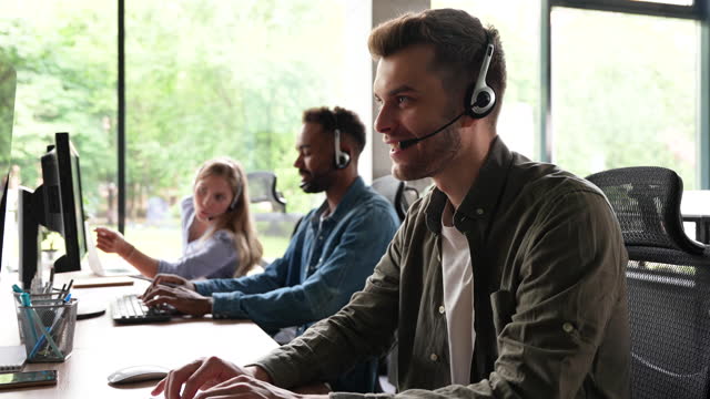 Male call center operator in headset helping client, working in customer support