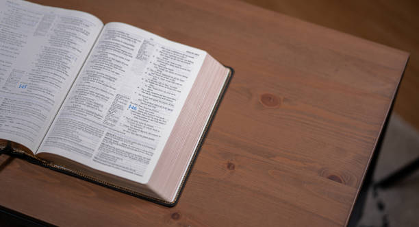 istock Open Bible sitting on a wood table 1423388927
