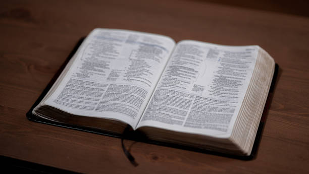 istock Open Bible sitting on a wood table 1423388938