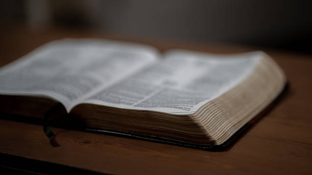 istock Open Bible sitting on a wood table 1423388941