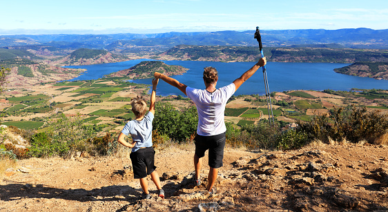 father and son hiker and enjoying panoramic view of France landscape (Salagou lake,  Herault)